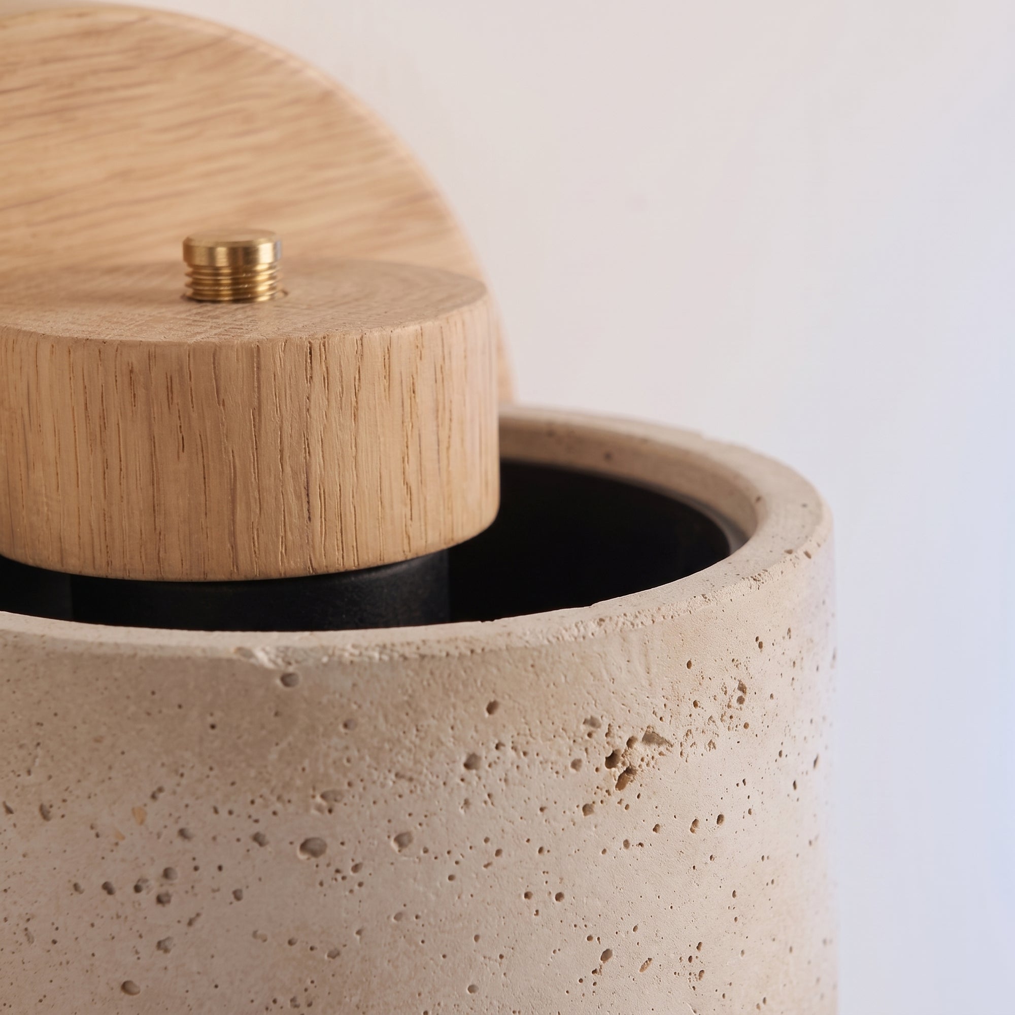 close detail of the iwa wall light stone-effect shade texture and oak pivot