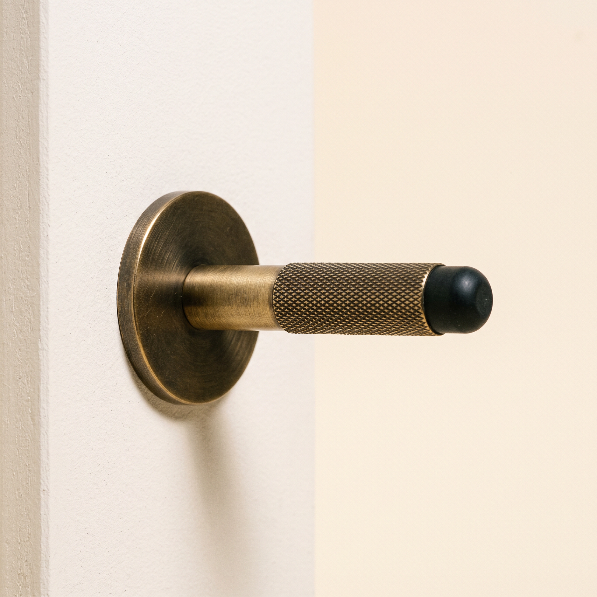 fell door stop in antique brass, studio shot
