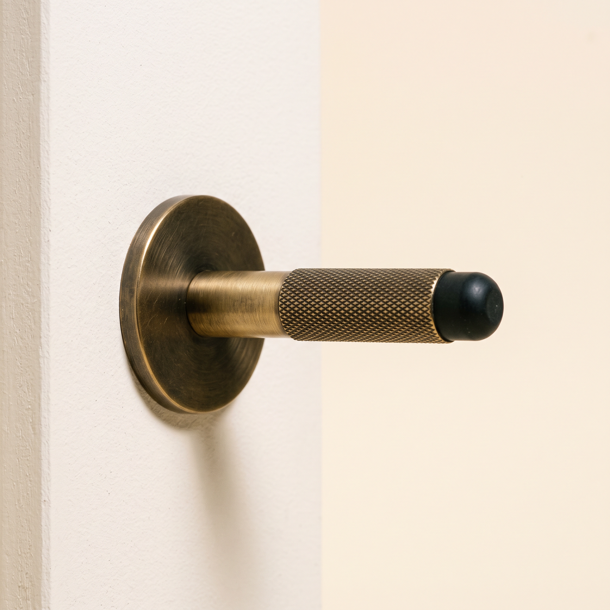 fell door stop in antique brass, studio shot