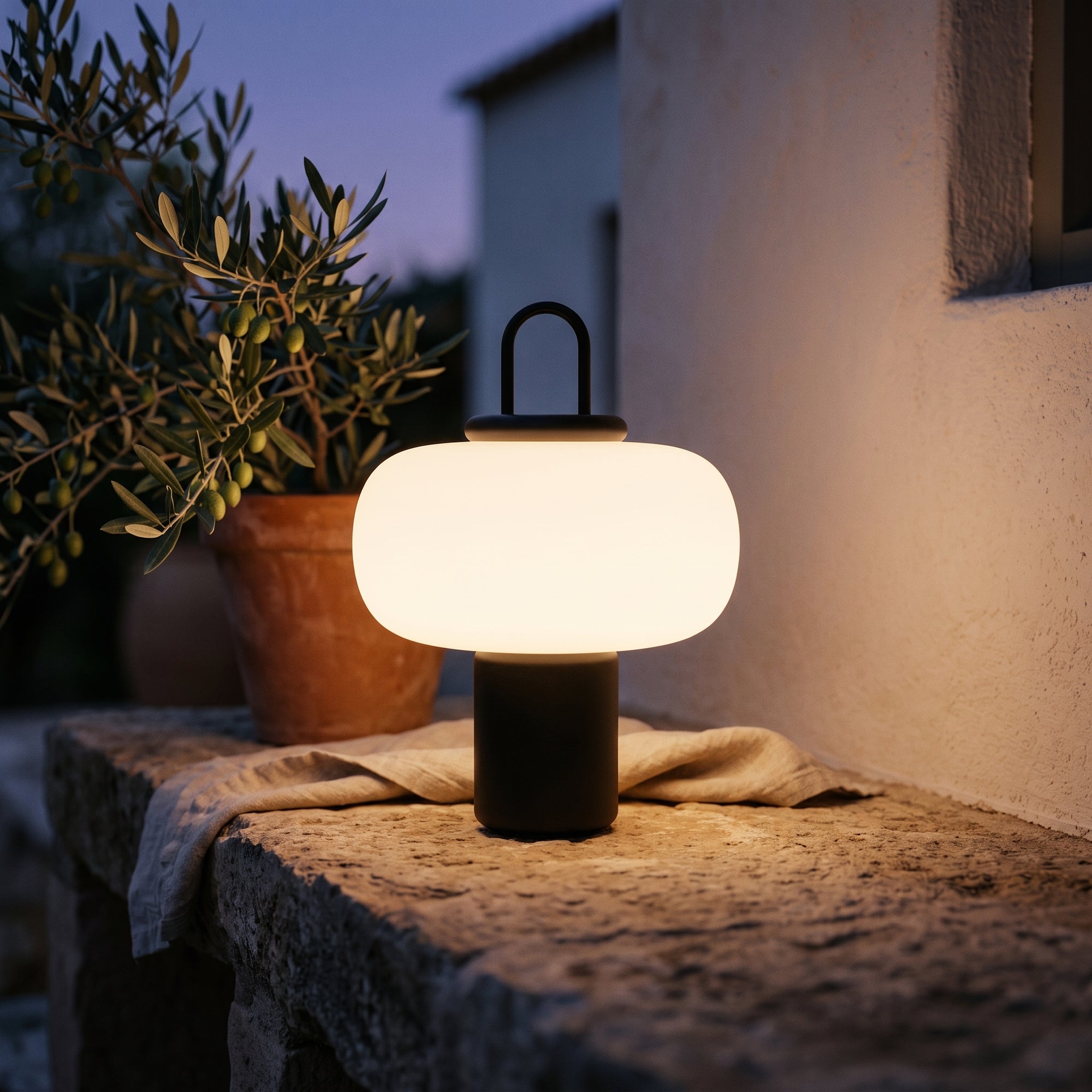 Loch table lamp on an outdoor courtyard ledge at dusk